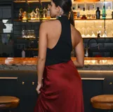 Falda midi de satén color bordó, con corte al bies y caída fluida.