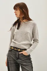 Sweater de punto color negro, con cuello redondo y mangas largas con puños acanalados.