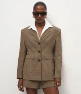 Blazer de sastrería con estampado pied de poule, corte estructurado, cuello con solapa clásica, cierre frontal de tres botones y bolsillos con solapa.