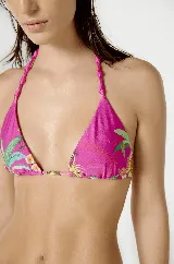 Conjunto de bikini Blueman fucsia con estampado de palmeras y tucanes. El corpiño es de triángulo con tiras trenzadas y detalle dorado en el centro. La bombacha es tipo colaless con tiras trenzadas a los costados.