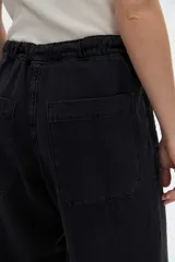 Jean estilo relaxed de color gris oscuro, con calce holgado, pierna amplia de caída fluida, cintura con cordón ajustable y bolsillos laterales.