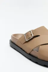 Sandalia negra con tiras cruzadas y hebilla metálica lateral.