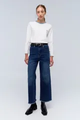 Jean de pierna ancha, tiro alto, color azul oscuro con desgaste en los muslos y ruedo desflecado.