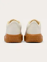 Championes Sorel modelo Ona Ave Low Sneaker, color blanco con suela alta de plataforma en tono caramelo y detalles dorados en los ojalillos y la marca en el lateral.