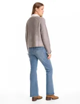 Buzo de tejido de punto acanalado color gris, con escote en V y lentejuelas incrustadas. Presenta un efecto combinado con cuello y puños de camisa blanca asomando por debajo.