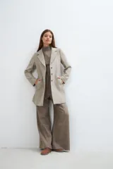 Saco corto entallado de lana fina, con cuello solapa, manga larga y cierre frontal con botones. Presenta un diseño clásico con textura de espiga en tonos tierra.