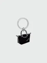Llavero Longchamp con dije en forma de bolso Le Pliage, color negro con contorno plateado y aro metálico con el nombre de la marca grabado.