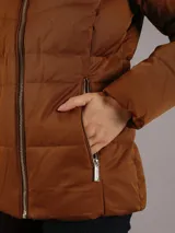 Campera marrón de poliéster y elastano con relleno acolchado, cierre frontal con cremallera, cuello alto y bolsillos laterales con cierre.