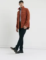 Pantalon de pana de corte recto con diseño de cinco bolsillos, incluyendo bolsillos traseros de parche y cierre con botones y remaches metálicos.