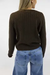 Sweater azul marino de punto con diseño de trenzas o espigas en relieve, cuello redondo y mangas largas con puños y dobladillo acanalados.