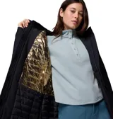 Campera tipo parka para mujer, color negro, con tecnología impermeable y transpirable. Cuenta con capucha ajustable forrada en sherpa con borde de piel sintética, cierre frontal bidireccional, cintura ajustable y múltiples bolsillos con cremallera. Incluye puños interiores acanalados para mayor protección contra el frío.