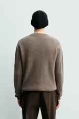 Jersey de punto canalé con cuello redondo y manga larga, confeccionado en hilatura de cashmere. Presenta un corte regular fit con acabados en rib en puños y bajo.