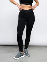Calza deportiva Umbro modelo Legging Bink para mujer, de color negro, con cintura alta cruzada y elástica con la marca estampada.
