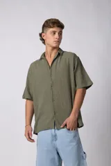 Camisa de manga corta confeccionada en lino, con cuello clásico y cierre frontal de botones. Presenta un corte relajado y textura liviana.