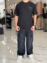 Remera oversize color beige, con diseño estampado en la espalda que incluye tipografía grande y texto descriptivo en negro.