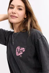 Remera de corte oversize color verde agua con efecto acid wash, cuello redondo y estampa pequeña en el pecho. Presenta una silueta relajada y mangas cortas.