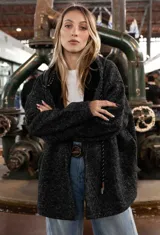 Campera tipo overshirt de paño jaspeado en color negro, con calce oversize, capucha y cordones trenzados. Presenta un diseño versátil con interior suave y abrigado.