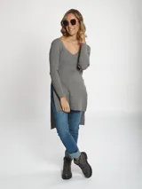 Buzo de tejido rib color gris, con cuello en V, mangas largas y diseño asimétrico con tajos laterales.