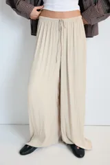 Pantalón de tiro medio, color negro, confeccionado en tejido satinado con diseño de pierna ancha y cintura elástica ajustable con cordón.