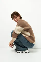 Sweater de punto con diseño geométrico en tres tonos de azul y gris, de cuello redondo y manga larga.