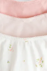 Pack de tres bombachas tipo thong de algodón con tiro bajo, bordes elásticos con detalle de encaje y refuerzo interior. Incluye una de color rosa, una beige y una blanca con estampado floreado.