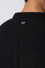 Camisa de manga larga confeccionada en tejido de lino con textura, de corte holgado y diseño versátil con cierre frontal de botones.