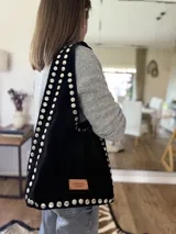 Bolso negro de gamuza con tachas plateadas.