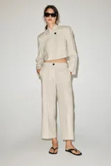 Pantalón culotte negro de tiro alto confeccionado en mezcla con lino. Cuenta con bolsillos delanteros y cierre frontal con botón.