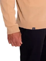 Sweater de punto color tostado, con cuello alto y medio cierre frontal, de manga larga y diseño regular.