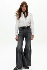 Pantalón de denim tiro alto con corte ajustado en la parte superior y ruedo acampanado con vuelo. Presenta un diseño de cinco bolsillos y cierre frontal con botón y cremallera.