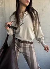 Sweater de punto color beige, con cuello polo y cierre frontal de botones, de manga larga con puños elásticos y diseño texturizado de rombos.