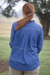 Camisa de algodón liviano color celeste, con manga larga, cuello camisero, bolsillo frontal con parche y etiqueta de marca, y pespuntes en contraste. Cuenta con cierre frontal oculto y botones de madera y coco.
