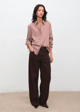 Camisa de corte recto con diseño de rayas verticales en tonos terracota y blanco. Presenta cuello camisero clásico, cierre frontal con botones y mangas largas con puños abotonados.