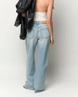 Jeans de tiro medio con corte recto desde la cadera hasta el bajo, de color celeste claro. Diseño clásico de cinco bolsillos con cierre de cremallera y botón metálico.