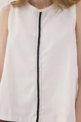 Top sin mangas de algodón texturado en color gris con diseño a rayas sutiles, cuello redondo y ribetes en azul marino. Presenta una costura vertical central con detalles de bordado.
