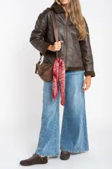 Campera tipo gamulán de corte oversize, color marrón oscuro con efecto cuero envejecido. Presenta cuello solapa, puños y ruedo con forro de corderito sintético en tono marrón oscuro. Cuenta con cierre frontal completo y detalles de costuras reforzadas.