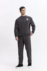 Buzo de algodón con calce oversize, cuello redondo, mangas largas con puños y bolsillos laterales. Presenta un parche cuadrado negro con lettering en el pecho y detalle de estampado en el ruedo.