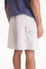 Bermuda cargo de felpa sin friza, color beige, con cintura elástica y bolsillos laterales con solapa.