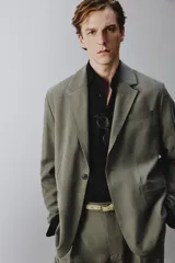 Blazer de corte relaxed fit confeccionada en tejido con mezcla de modal, en color verde militar. Presenta cuello con solapas de muesca, cierre frontal con un botón, bolsillos de vivo en el pecho y bolsillos con solapa en la cadera. Forro interior a rayas y abertura en el centro de la espalda.