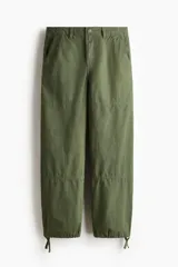 Pantalón de corte relajado confeccionado en tejido ripstop, con cierre de botón a presión, bolsillos al bies y bolsillos traseros de parche. Presenta costuras horizontales en las piernas y cordón ajustable en los bajos.