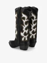 Bota tejana larga de cuero color negro con diseño de llamas o motivos abstractos en blanco y tachas doradas. Presenta punta cuadrada y taco bajo de estilo western.