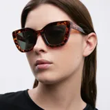 Lentes de sol cat-eye con montura carey y lentes polarizadas verdes oscuras.