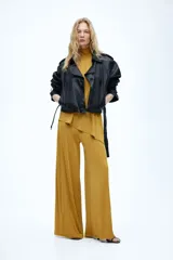 Pantalón holgado de punto suave color mostaza con elástico oculto en la cintura y perneras amplias.