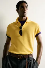 Sudadera polo regular fit de manga corta color mostaza, confeccionada en tejido con mezcla de algodón e interior de rizo, con cuello solapa y cierre frontal de botonadura.