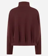 Campera de modal color marrón, con cuello alto, cierre frontal completo y diseño con pliegues en el ruedo. Presenta mangas largas y un calce holgado.