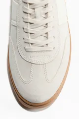 Zapatillas deportivas de inspiración retro en tejido cepillado suave de color beige, con cordones, collarín acolchado, detalles en tejido revestido y suela de goma marrón.