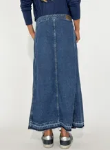 Pollera larga de jean negro con corte evasé, cierre lateral con botones y ruedo desflecado.