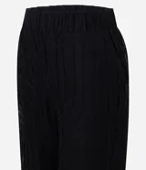 Pantalón de tricot negro con corte wide leg, transparencia delicada y bordado abstracto en relieve. Cuenta con cintura elástica y caída fluida.