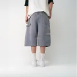 Bermuda de jean estilo baggy, con corte holgado y largo por debajo de la rodilla. Presenta un acabado en color gris con efecto desgastado, cierre frontal con botón y bolsillos laterales.