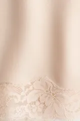 Top de satén color rosa claro, con escote en V pronunciado, breteles finos ajustables y detalles de encaje floral en el escote y en el ruedo.